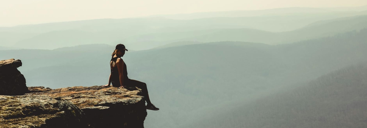 woman sitting on edge of rock formation
