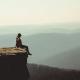 woman sitting on edge of rock formation